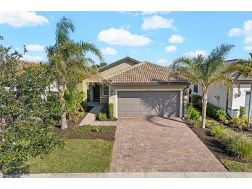 Single-story home with tile roof, attached garage, and landscaped yard at 12861 Oriago St, Venice, FL 34293