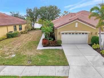 Single-story home with tile roof, two-car garage, and landscaped yard at 1375 Maseno Dr, Venice, FL 34292