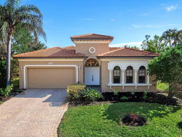 One-story home with tile roof, landscaped yard, and two-car garage at 249 Rio Terra, Venice, FL 34285