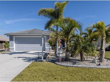 Gray house with attached garage,palm trees,landscaped yard at 4251 Oak Terrace Cir, Port Charlotte, FL 33953