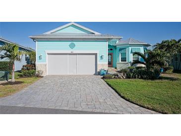 Charming, light blue home with a brick driveway and well-manicured landscaping offering great curb appeal at 8817 Conch Ave, Placida, FL 33946