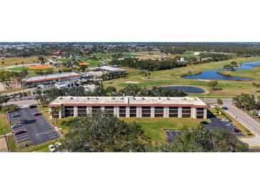 Wide angle shows the building exterior, parking lot, golf course, and other nearby recreational features at 104 Capri Isles Blvd # 107, Venice, FL 34292