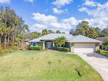 Well-maintained single-story home with lush landscaping, lawn, and charming curb appeal at 1232 Marilyn Ln, North Port, FL 34286