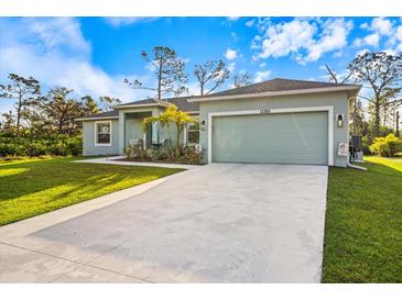 Single-story home with attached garage and landscaped front yard at 12385 Prudential Ave, Port Charlotte, FL 33981