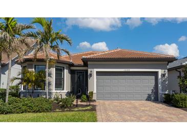 Charming single-story home with well-maintained landscaping, brick driveway, and terracotta roof at 13194 Borrego St, Venice, FL 34293