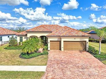 Single-story home with tile roof, two-car garage, and landscaped yard at 13376 Caravaggio Ct, Venice, FL 34293