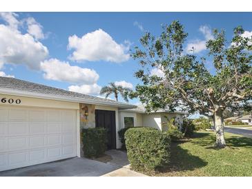 A view of the front exterior showing the garage and stone accent wall at 1600 Lilliput Ct, Venice, FL 34293