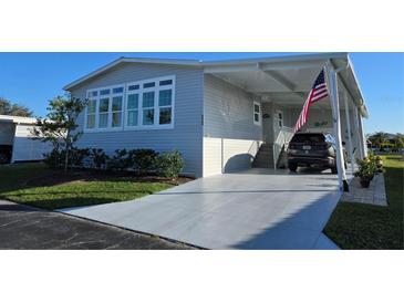 Charming home with a well-manicured lawn, a gray driveway and an American flag at 530 Walnut Cir, Venice, FL 34285