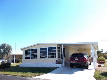 Mobile home with carport and landscaped yard at 562 Longwood Dr, Venice, FL 34285