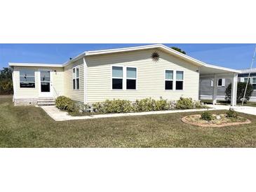 Charming home with a well-manicured lawn and covered parking offers inviting curb appeal at 590 Portside Dr, North Port, FL 34287