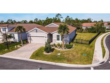 Single-story home with tile roof, landscaped yard, and driveway at 600 Nasturtium Ct, Nokomis, FL 34275