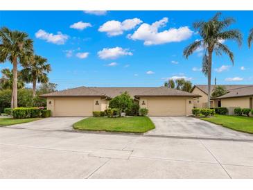 Charming villa with a lush green lawn, beautiful landscaping, and a two-car garage in a serene neighborhood at 7145 Lakeside Dr, Sarasota, FL 34243