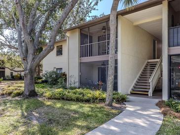 Charming condo building with mature trees and lush landscaping surrounding the property at 748 White Pine Tree Rd # 208, Venice, FL 34285