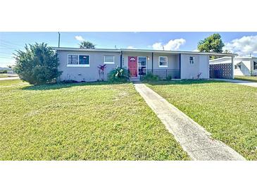 Charming single-story home featuring a red front door and well-maintained lawn at 7903 Hyde Park Ave, North Port, FL 34287