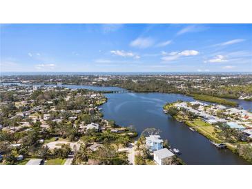 Breathtaking aerial view showcasing waterfront property with lush landscaping and serene water views at 807 Lucille Ave, Nokomis, FL 34275