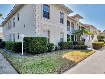 A charming two-story condo with well-manicured landscaping, under a clear blue sky, creates a welcoming exterior view at 9204 L Pavia Blvd # 9204, Venice, FL 34292