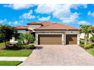 Beautiful single-Gathering home featuring a red tile roof, three-car garage, and a paved driveway at 13730 Vancanza, Venice, FL 34293