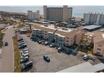 An aerial view shows the building's proximity to the beach and ample parking spaces for residents and guests at 200 The Esplanade N # B10, Venice, FL 34285
