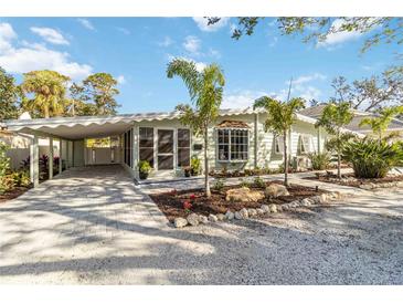 Charming single-story home featuring a carport and tropical landscaping at 432 Palmetto Ct, Venice, FL 34285