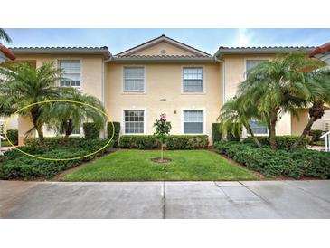 Charming townhouse featuring well-manicured lawn and lush landscaping with mature palm trees at 4425 Corso Venetia Blvd # A20, Venice, FL 34293