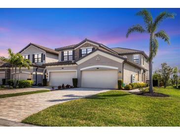 Charming two-story home with paver driveway, attached two-car garage, and lush tropical landscaping at 5921 Wake Forest Run # 104, Bradenton, FL 34211