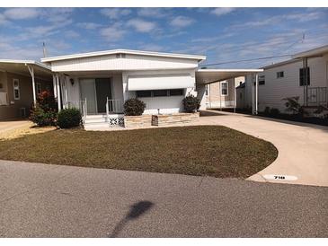 Charming single-story home featuring a covered carport and well-maintained lawn at 718 S Green Cir, Venice, FL 34285