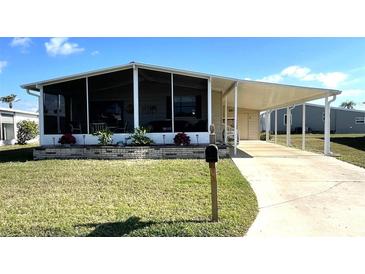 Charming home featuring a carport, a lovely front yard, and a screened-in porch at 210 Schooner St, North Port, FL 34287