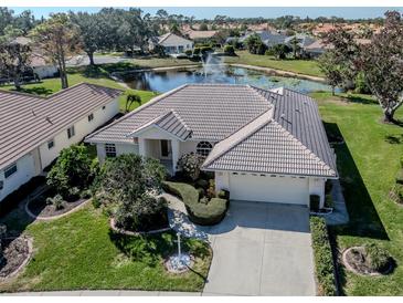 Stunning home with lush landscaping and a pond view, complete with fountain at 5071 Winter Rose Way, Venice, FL 34293