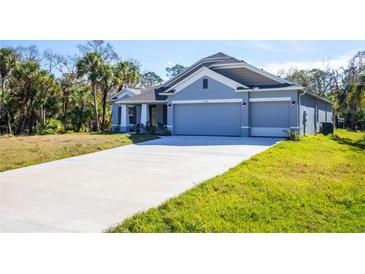 Inviting single-story home featuring a 3-car garage and a long driveway at 5637 Ocarina Rd, North Port, FL 34291