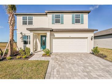 Two-story home with a paved driveway and landscaped lawn at 101 Runaway Field Ave, Nokomis, FL 34275