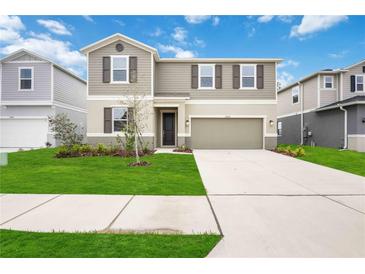 Two-story house with a two-car garage and landscaped lawn at 37488 Williamette Way, Zephyrhills, FL 33540