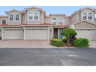 Three-story townhome with two-car garage and landscaped front at 1344 Ribolla Dr, Palm Harbor, FL 34683