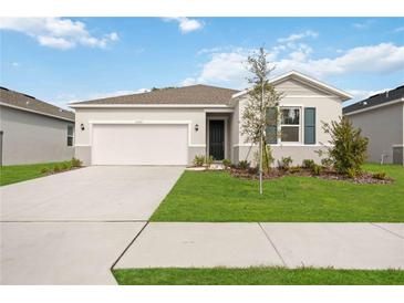 One-story home with a two-car garage and landscaped lawn at 37501 Williamette Way, Zephyrhills, FL 33540