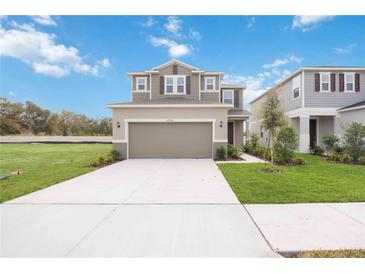 Two-story house with attached garage and landscaped yard at 37736 Yukon Dr, Zephyrhills, FL 33540