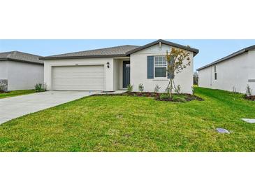 Single-story home with a white exterior, two-car garage, and landscaped lawn at 7760 Gilchrist Springs Dr, Parrish, FL 34219