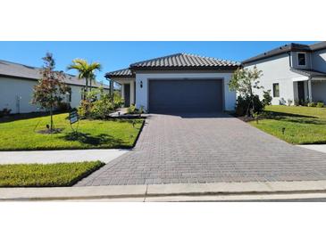 Single-story home with gray paver driveway and landscaped lawn at 6052 Baywood Ct, Lakewood Ranch, FL 34211