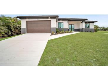 Modern single-story home with brown garage door and landscaped lawn at 16229 Cape Horn Blvd, Punta Gorda, FL 33955