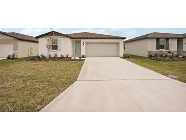 Charming single-story home showcasing a well-manicured lawn and a spacious driveway leading to an attached garage at 7818 Gilchrist Springs Dr, Parrish, FL 34219