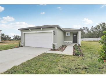 Newly constructed home with a white garage door and landscaped front yard at 3622 Moscato Dr, Brooksville, FL 34602