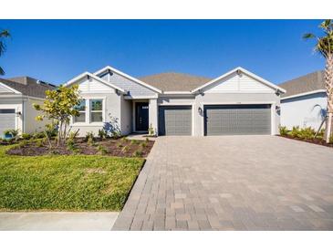 One-story home with gray two-car garage and landscaped front yard at 1564 Laurel Brook Ln, Port Charlotte, FL 33953