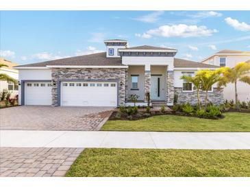 Beautiful single-Gathering home showcasing a manicured lawn and a three-car garage at 1044 Signet Dr, Apollo Beach, FL 33572