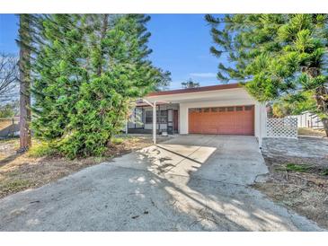 House exterior showcasing carport and orange garage door at 990 Sunrise Dr, Tarpon Springs, FL 34689
