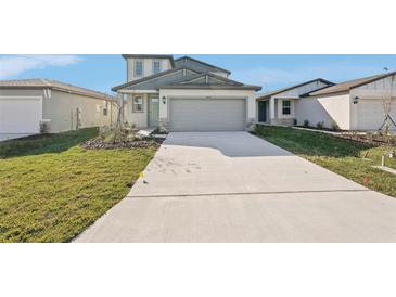 Two-story house with gray siding, two-car garage, and a landscaped lawn at 14057 Crutchfield Ct, Parrish, FL 34219