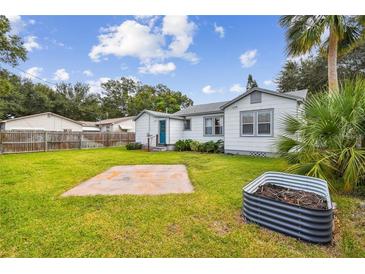 Large backyard with grassy lawn, concrete patio, and raised garden bed at 1535 35Th N Ave, St Petersburg, FL 33704