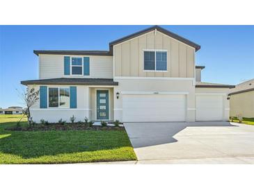Two-story house with a two-car garage and teal accents at 13868 Richland Gulf Cir, Parrish, FL 34219