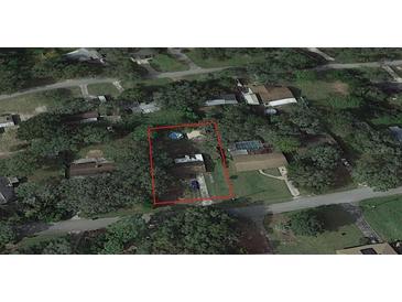 Aerial view showing a single-story house with a pool in a residential neighborhood at 4935 Mockingbird Dr, Dade City, FL 33523