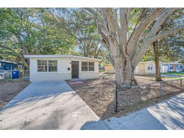 Charming bungalow home with a large tree and a paved driveway at 634 Newton S Ave, St Petersburg, FL 33701