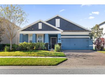 Two-story house with blue siding, gray roof, and a two-car garage at 1570 Fox Grape Loop, Lutz, FL 33558