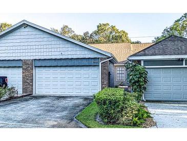 Front view of charming villa with attached garage and well-manicured landscaping at 1713 Castle Rock Rd, Tampa, FL 33612