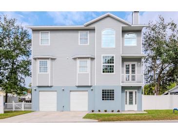 Two-story house with gray siding, three-car garage, and a balcony at 320 Georgia Ave, Crystal Beach, FL 34681